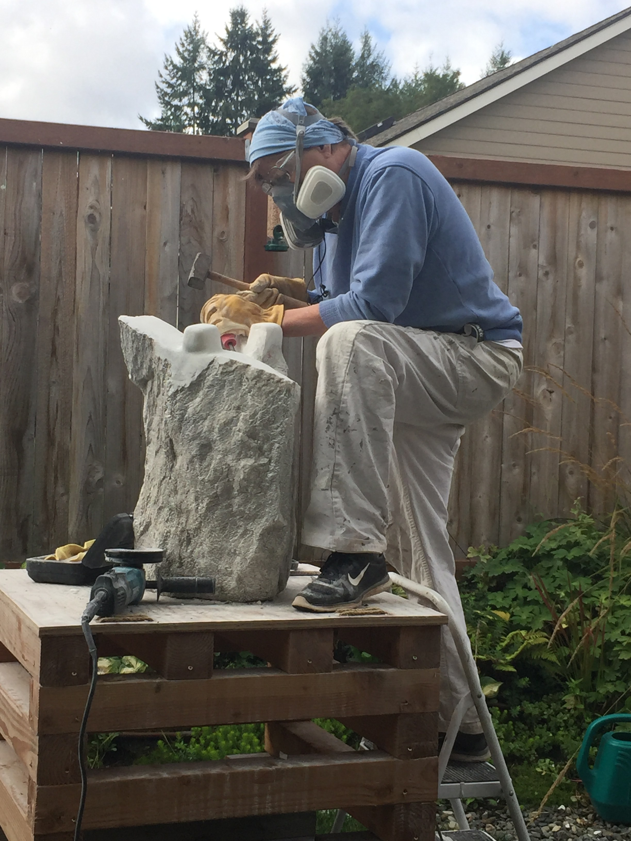LeeAnn Seaburg Perry carving stone in her outdoor studio
